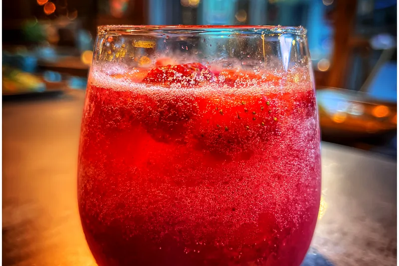 A vibrant display of fresh strawberries, mint, and champagne ingredients for making the punch.