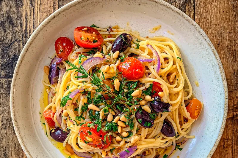 Fresh ingredients for Mediterranean One Pot Dish including chicken, vegetables, and herbs displayed on a wooden table.