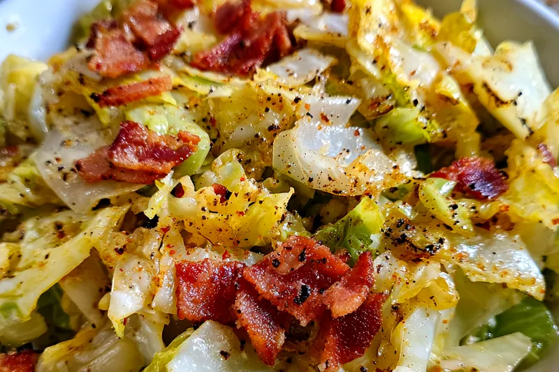 Chef cooking Savory Southern Fried Cabbage in a skillet, showcasing the vibrant colors and textures.